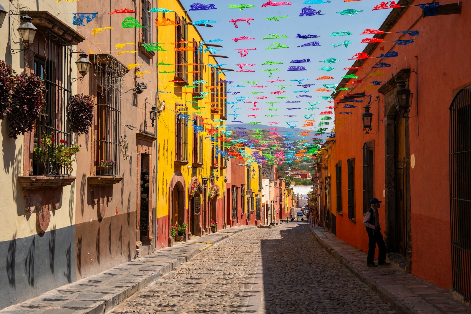Cobblestone street under colorful papel picado in San Miguel de Allende