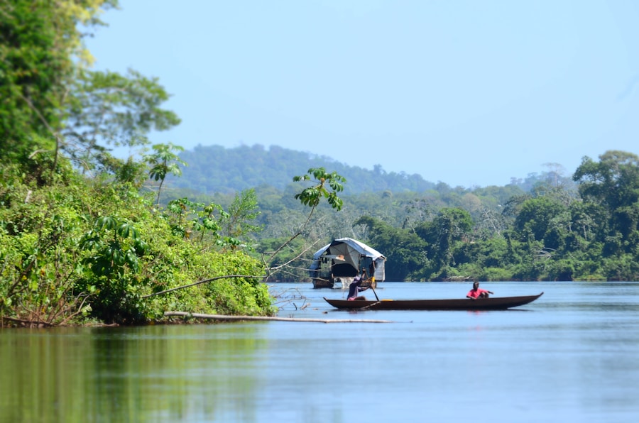 Two travelers paddling a small boat on a wide river