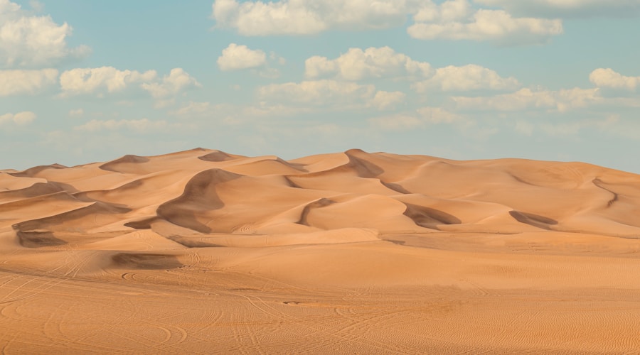 Golden Dubai desert dunes rolling under a wide blue sky